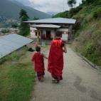 Tandi Dorji (izquierda), aprendiz de monje de ocho años, habla con un monje mayor mientras se dirigen al comedor del monasterio en Thimphu, Bután. La imagen es del 4 de junio de 2013.