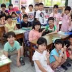 El estudiante de primaria Ryan Kao (en el suelo a la izquierda), posa para una foto con sus compañeros de clase en Taipei el 5 de junio de 2013.