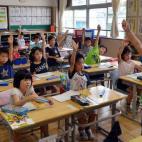 El alumno de la escuela de primaria Seishi Nishida levanta la mano junto a sus compañeros de clase en Tokio, el 11 de junio de 2013.