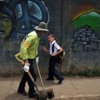 El costarricense Gerald Sequeira, de 8 años, saluda al barrendero mientras se dirige al colegio, el 22 de agosto de 2013.
