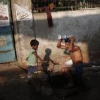 Un hombre se baña en la calle en el casco antiguo de Delhi.