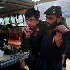 Un guardia de seguridad del hospital ayuda a un estudiante herido. (AP Photo/Mohammad Sajjad)