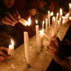 Activistas del Pakistan Tehreek e Insaaf (PTI) encienden velas por las víctimas del ataque talibán en una escuela de Peshawar. (ASIF HASSAN/AFP/Getty Images)
