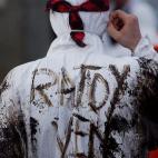 Un voluntario con el siguiente mensaje escrito con fuel en su espalda: "Rajoy, ven".