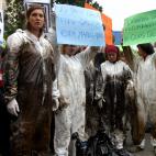 Voluntarios manifestándose en la Puerta de Sol en Madrid, con los trajes manchados de crudo.