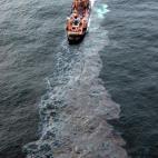 El reguero de fuel que dejaba el petrolero tras abrirse una vía de agua.