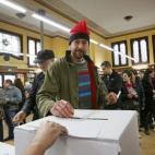 Un ciudadano, con barretina, deposita su papeleta.