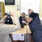 Una de las primeras personas en depositar su voto en el Instituto Frederic Mompou de Sant Viçenc dels Horts (Barcelona) se fotografía junto al presidente de Esquerra Republicana de Catalunya (ERC), Oriol Junqueras, que preside una de las mesas.