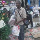 La epidemia de ébola no impide que la gente salga a comprar adornos navideños. (AP Photo/Abbas Dulleh)