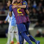 Barcelona's Argentinian forward Lionel Messi (R) is congratuled by his teammate Barcelona's Brazilian defender Daniel Alves (L) after scoring during the Spanish League football match Barcelona vs Malaga at the Camp Nou stadium in Barcelona on Ma...