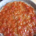 Estirarla (mejor si es casera) sobre la masa de la pizza.