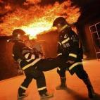 Miembros de un equipo de rescate de emergencias trasladan a una persona en un simulacro en Puyang (China).