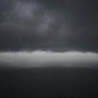 Vista de nubes mientras helicópteros y un buque de la armada indonesia se acercan al área dónde se ha encontrado la cola del avión de AirAsia desaparecido.