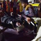 Sanitarios y personal de emergencia atiende a uno de los heridos en la doble explosi&oacute;n