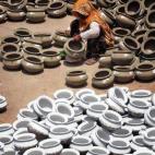 Una alfarera paquistaní da los últimos retoques a las vasijas de barro en un taller de Lahore.