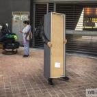 Verónica Labradas permanece de pie fuera de su piso mientras un hombre la ayuda a sacar sus cosas, tras haber sido desahuciada, en octubre de 2014. Labradas y su familia ocuparon un piso hace seis meses al no poder pagar el alquiler por haber p...