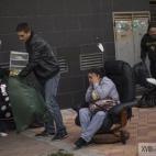 Veronica Labradas, en el centro de la imagen, permanece fuera de su vivienda con sus pertenencias tras haber sido desahuciada.