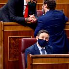 Los diputados de Vox Iv&aacute;n Espinosa de los Monteros y Javier Ortega Smith conversan ante su l&iacute;der, Santiago Abascal, durante la segunda sesi&oacute;n del debate.