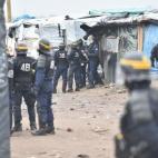 Policemen walk between shelters as agents dismantle shacks on March 1, 2016 in the 'Jungle' migrant camp in the French northern port city of Calais. Workers were due to start a second day of destruction in the southern half of the camp, where th...