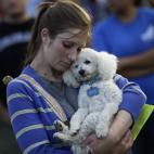 Una mujer abraza a su perro tras la masacre de Aurora en 2012 en Colorado, donde se produjo un tiroteo en el estreno de la película El Caballero Oscuro.