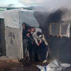 CALAIS, FRANCE - FEBRUARY 29: Activists hide from a water cannon as part of the 'jungle' migrant camp is cleared on February 29, 2016 in Calais, France The French authorities have begun dismantling part of the migrant encampment in the northern...