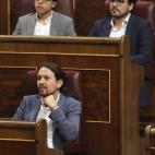 Iglesias atiende a la intervenci&oacute;n de la portavoz de su partido. Sobre &eacute;l, &Iacute;&ntilde;igo Errej&oacute;n y Alberto Garz&oacute;n, de Unidos Podemos.
