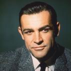 Sean Connery, British actor, wearing a grey tweed jacket, a white shirt and a black tie, in a studio portrait, against a dark green background, circa 1960. (Photo by Silver Screen Collection/Getty Images)