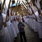 Un chico junto a los penitentes de "La Amargura" en Sevilla