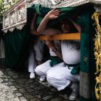 Costaleros durante la procesión de la hermandad de "Redención" en Sevilla.