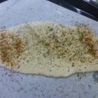 Cubrir la bandeja con papel de horno, así no se pegará la pizza. Espolvorear con un orégano, albahaca, pimienta negra, tomillo y especias.