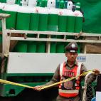 Un agente de polic&iacute;a tailand&eacute;s vigila el &aacute;rea de bloqueo frente a tanques de ox&iacute;geno almacenados en un cami&oacute;n.