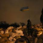 Una niña sostiene una bandera ucraniana en una barricada entre la policía y los manifestantes en Kiev, Ucrania.