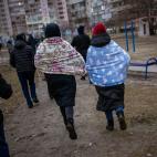 Gente corriendo a buscar refugio mientras suenan las sirenas que avisan de nuevos ataques en la ciudad de Kiev. (AP Photo/Emilio Morenatti)