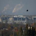 Imagen del 17 de octubre de 2014 que muestra en primer plano la terminal principal del aeropuerto, destrozada, y en segundo plano la planta química Avdeyevsky, aún en funcionamiento.