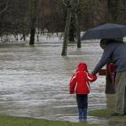 Un hombre y un niño ante el desbordamiento del río Arga, en la zona de la Rotxapea de Pamplona, que ha anegado parques y calles en la capital navarra.