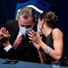 Rey y reina conversan entre aplausos