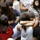 Compañeros de Asunta se abrazan durante el entierro de la pequeña.