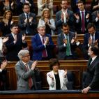 Los miembros de su partido le reciben con un aplauso.