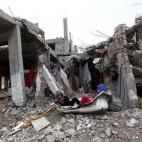 Niños palestinos juegan entre los escombros de casas, destruidas durante los ataques aéreos israelíes, en el barrio Shujaiyya de la ciudad de Gaza, el 6 de enero de 2015.