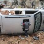 Niños sirios juegan en un coche destruido en el centro de la ciudad siria de Kobani el 18 de febrero de 2015. La ciudad acababa de ser liberada de las fuerzas del Estado islámico.