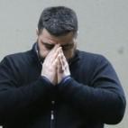 Un hombre que esperaba en el aeropuerto de Dusseldorf la llegada del vuelo 4U9525 desaparecido se cubre la cara.