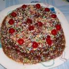 Con harina de arroz y almendras molidas y con un baño de azúcar, canela y ralladura de limón. Puedes ver aquí cómo prepararla.