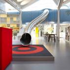 Un tobogán que conecta dos plantas y que realza el carácter juguetón de una empresa de juguetes.