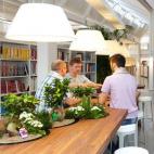 Mesas en la biblioteca con pequeños jardines de bonsáis.