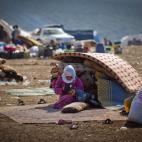 Una familia siria que huyó de la violencia en su villa descansa junto a sus pertenencias en un campamento de refugiados en el poblado sirio de Atma, cerca de la frontera entre Siria y Turquía. el miércoles 7 de noviembre de 2012. Vocero de gr...