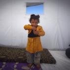 En esta foto del miércoles 7 de noviembre de 2012 aparece Fátima Zatar, de 2 años, quien huyó con su familia de la violencia en su comunidad. Zatar posó dentro de una carpa en un campamento de refugiados cercano a la aldea de Atmeh, junto a...