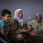 Abu Ahmed, de 74 años, y su esposa Sofiya, de 65, desplazados sirios de Mara, y su nieto, hablan en un campo de refugiados improvisado en la frontera con Turquía, cerca de la villa de Azaz, en Siria. (AP foto/ Manu Brabo)