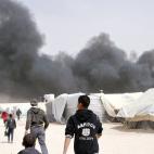 Humo negro se levanta sobre el campamento para refugiados sirios de Zaatari, en el noreste de Jordania, el viernes 8 de marzo de 2013. No hubo víctimas a causa del incendio que destruyó al menos 20 tiendas de campaña, según autoridades de la...