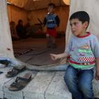 Un niño sirio se sienta afuera de la casa de campaña de su familia en el campo de refugiados para sirios, en Ketermaya, sureste de Líbano, el jueves 14 de marzo de 2013. (Foto AP/Hussein Malla)