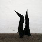 Penitentes de la hermandad de Los Dolores caminan hacia la iglesia durante la Semana Santa en Córdoba.